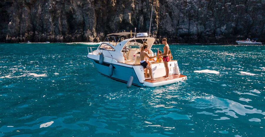Puerto Colón: Coastal Boat Cruise with Swimming and Snacks - A small boat view of Tenerife’s south coast